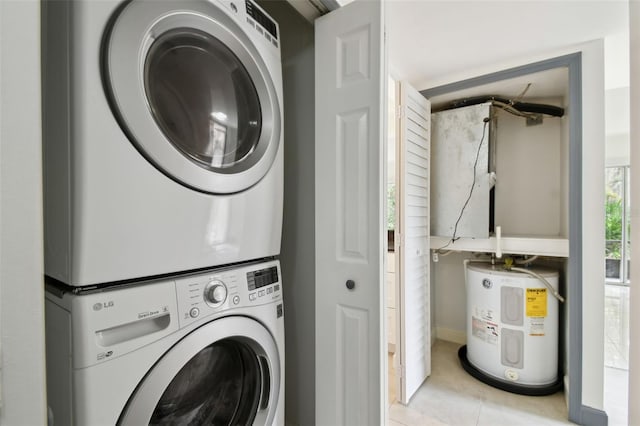 washroom featuring laundry area, light tile patterned floors, stacked washer / dryer, and electric water heater