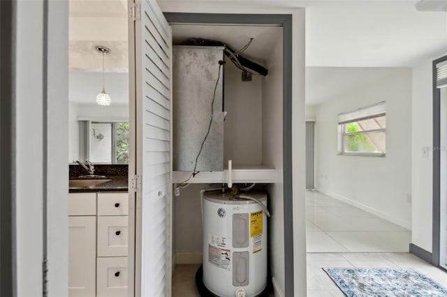 utility room with water heater and a sink