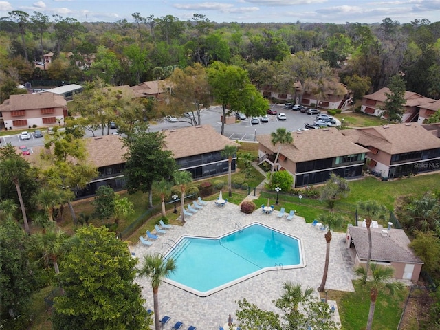 community pool with a residential view, a patio area, and fence
