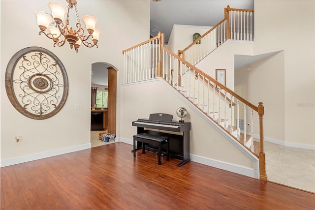 entrance foyer with a towering ceiling, baseboards, and wood finished floors