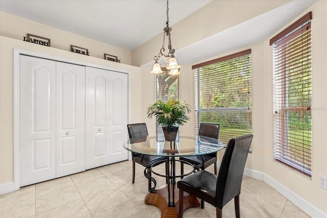 dining area featuring light tile patterned flooring, baseboards, and an inviting chandelier