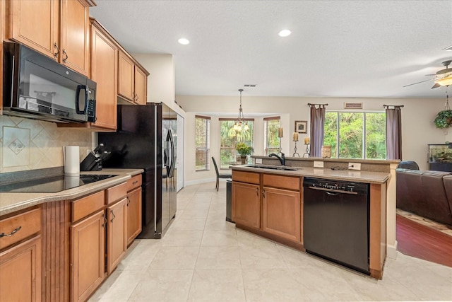 kitchen featuring black appliances, brown cabinets, and a sink