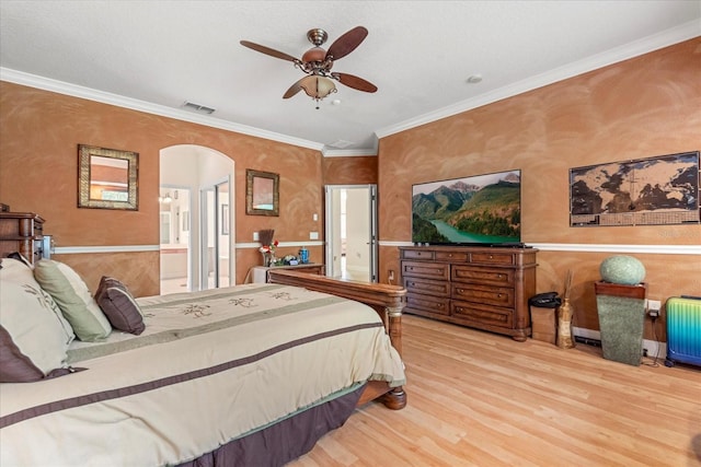 bedroom with arched walkways, wood finished floors, visible vents, ornamental molding, and radiator