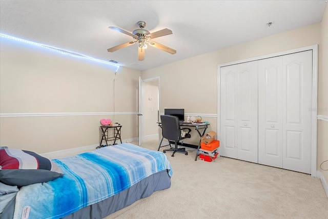 carpeted bedroom featuring a closet, visible vents, and ceiling fan