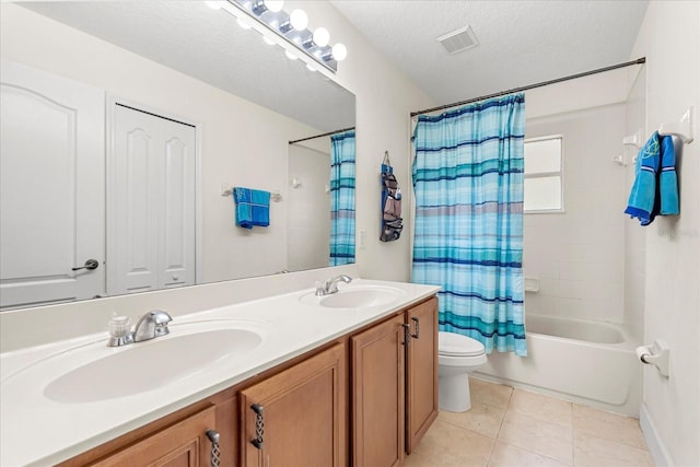 bathroom with a textured ceiling, a sink, visible vents, and tile patterned floors