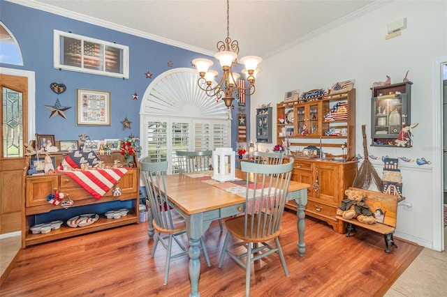 dining room with a notable chandelier, crown molding, and wood finished floors