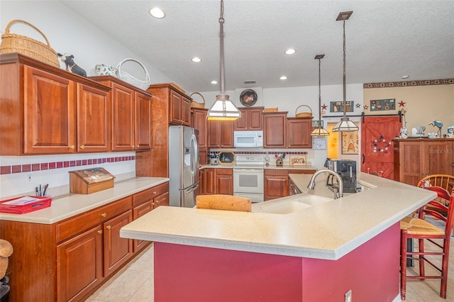 kitchen with white appliances, light tile patterned floors, a kitchen breakfast bar, light countertops, and a sink