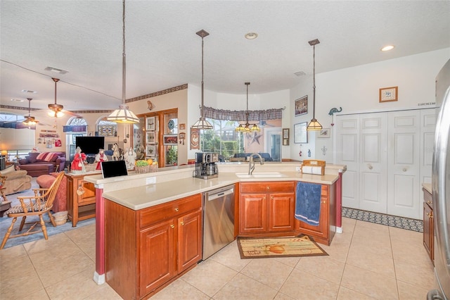 kitchen with light tile patterned floors, open floor plan, stainless steel dishwasher, and light countertops