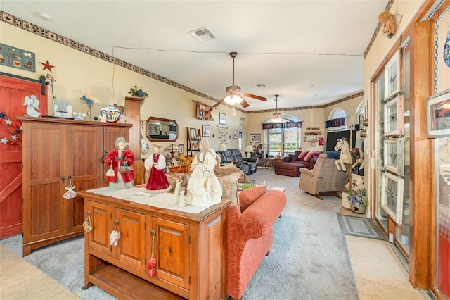 living area featuring visible vents, ceiling fan, and light tile patterned floors