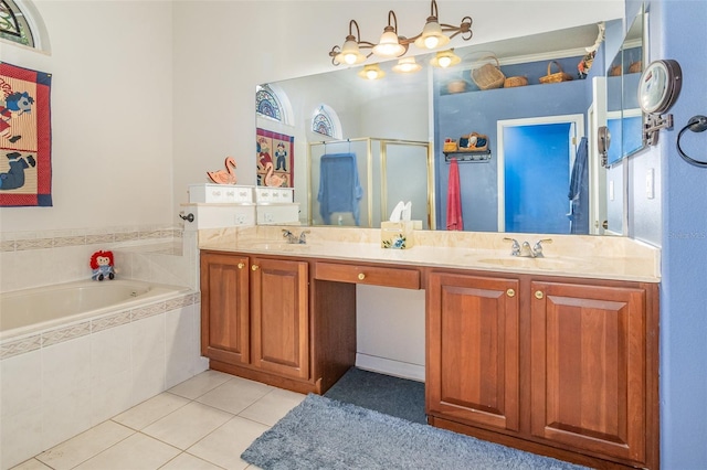 bathroom featuring a stall shower, tile patterned flooring, a sink, and double vanity