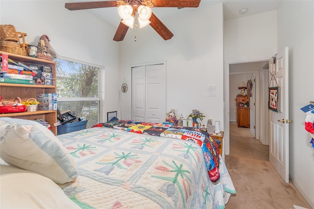 bedroom with a ceiling fan, a closet, a towering ceiling, and light colored carpet