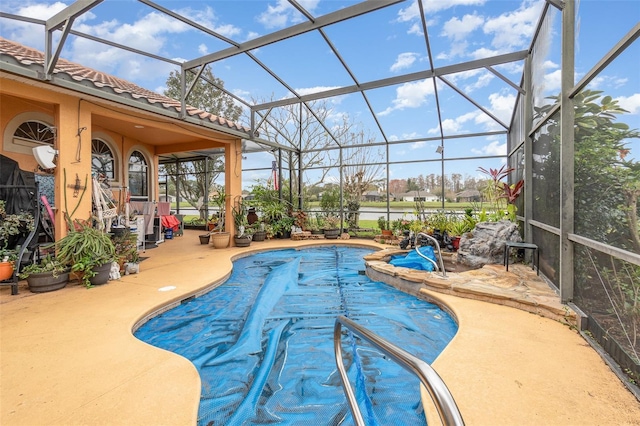 view of swimming pool featuring a patio, a pool with connected hot tub, and glass enclosure