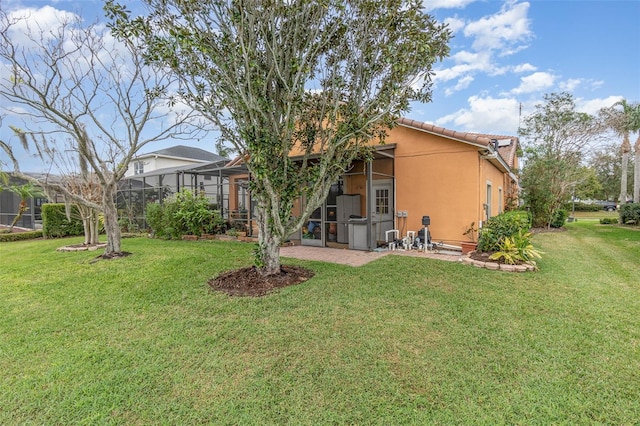 rear view of property featuring glass enclosure, a lawn, a tiled roof, and stucco siding