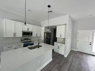 kitchen with stainless steel appliances, dark wood-style flooring, a sink, and white cabinetry