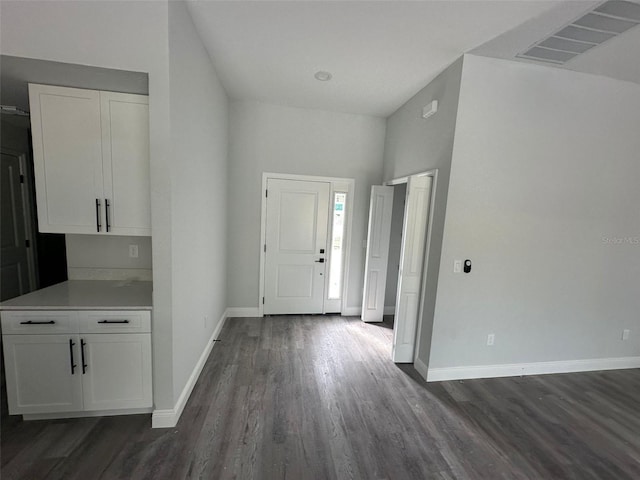 foyer entrance with baseboards, visible vents, and dark wood-type flooring