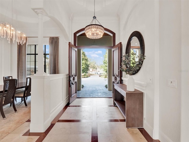 foyer entrance featuring baseboards and a chandelier