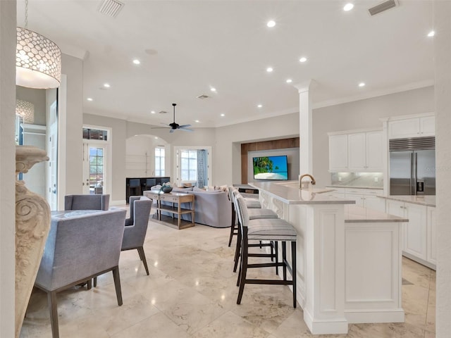 kitchen with built in fridge, marble finish floor, visible vents, and white cabinetry