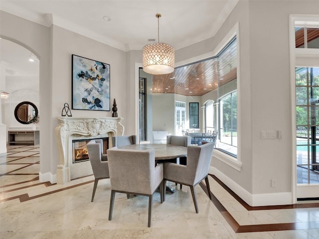 dining room featuring a high end fireplace, a wealth of natural light, baseboards, and recessed lighting