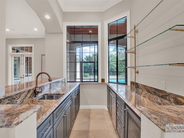 kitchen with stone counters, wine cooler, french doors, recessed lighting, and a sink