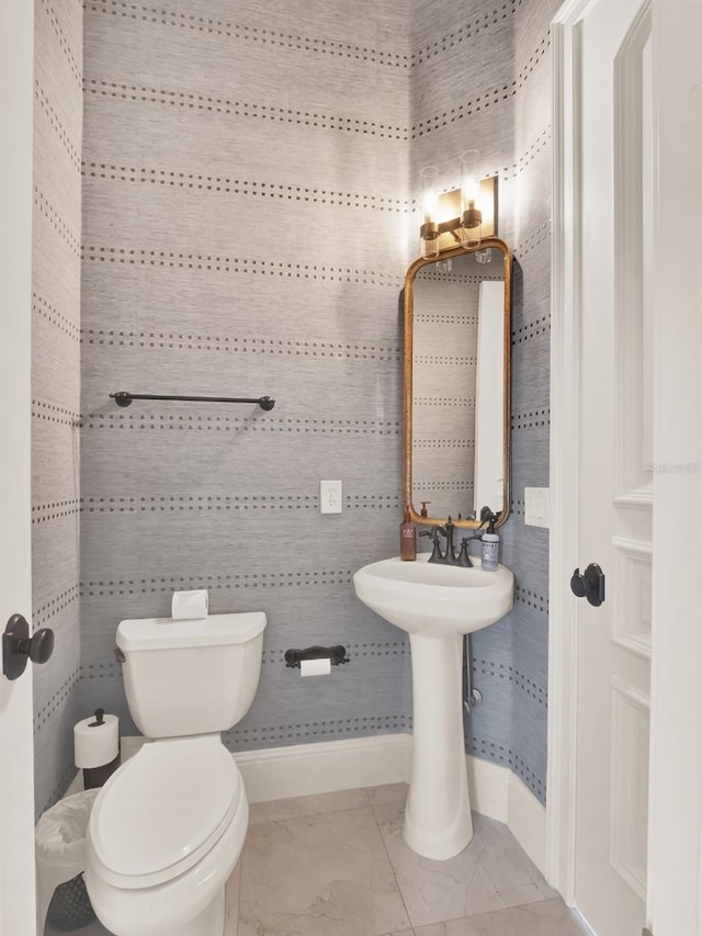 bathroom with toilet, tile patterned flooring, and baseboards