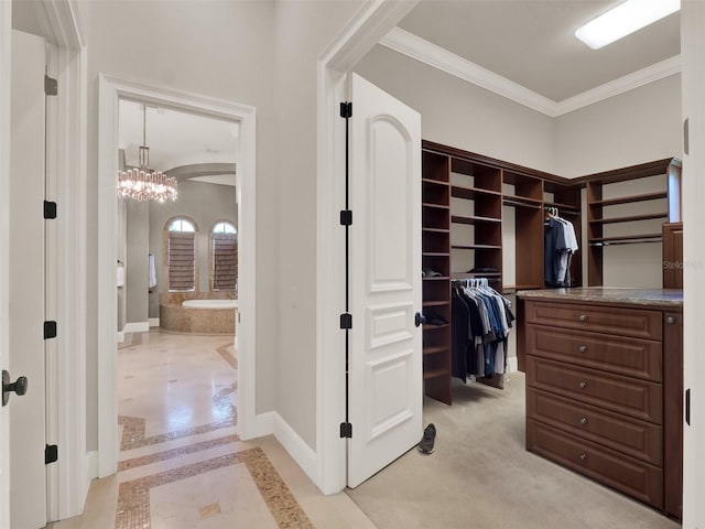 walk in closet with an inviting chandelier