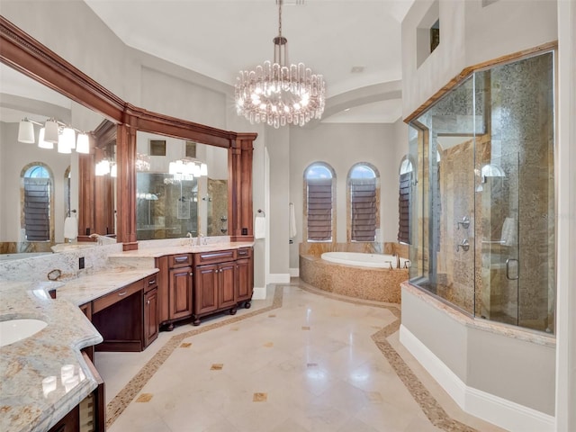 bathroom featuring a garden tub, a notable chandelier, a shower stall, vanity, and baseboards