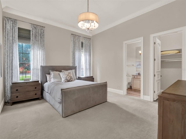 bedroom with a walk in closet, carpet flooring, ensuite bath, and baseboards