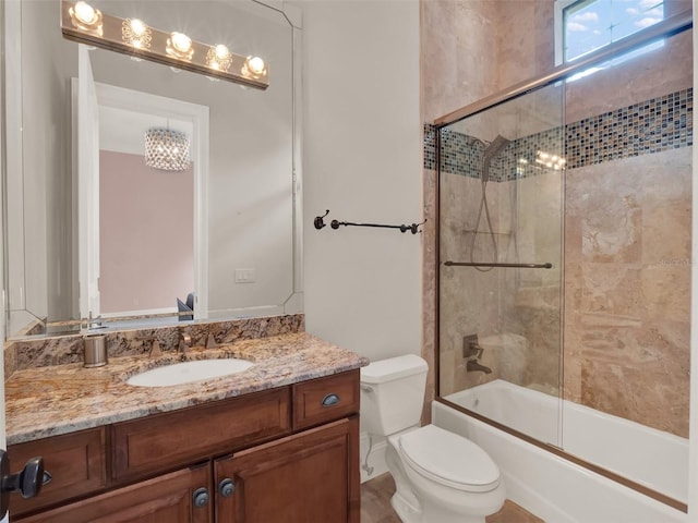 bathroom featuring enclosed tub / shower combo, vanity, and toilet