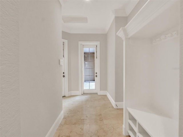 hall featuring baseboards and crown molding