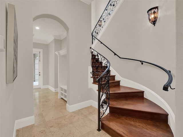 stairs featuring baseboards, arched walkways, and recessed lighting