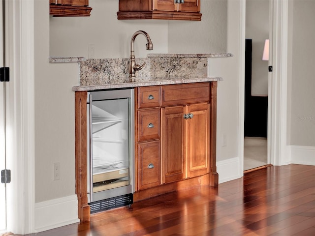 bar with dark wood-style floors, wine cooler, a sink, and wet bar