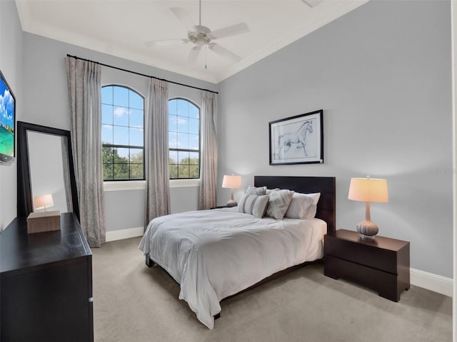 bedroom featuring ornamental molding, light carpet, ceiling fan, and baseboards