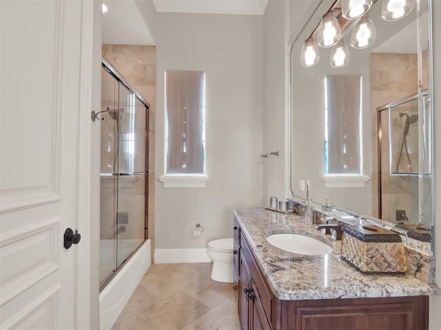 full bath featuring enclosed tub / shower combo, baseboards, vanity, and toilet