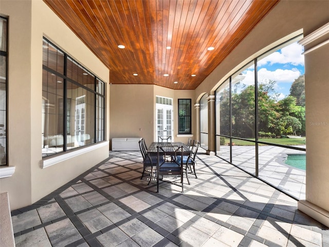 sunroom with wood ceiling and plenty of natural light