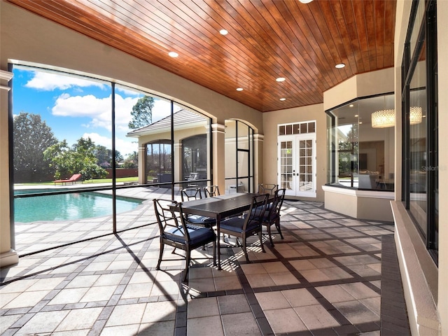 unfurnished sunroom featuring wood ceiling, a swimming pool, and french doors