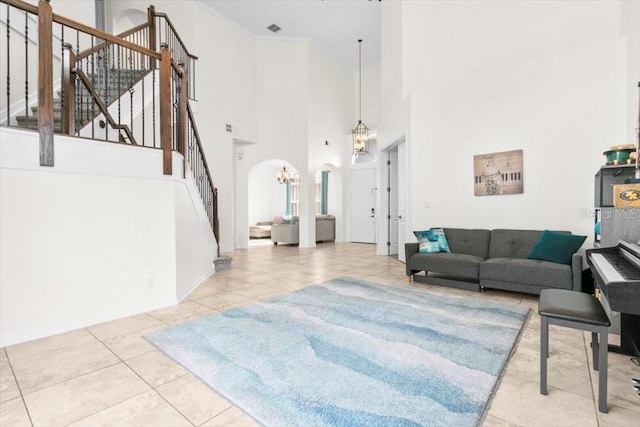 tiled living area featuring arched walkways, stairway, a chandelier, and visible vents