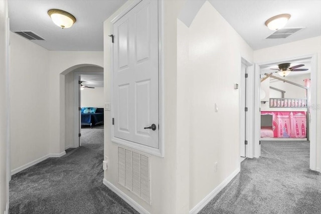 hallway featuring carpet, visible vents, and arched walkways