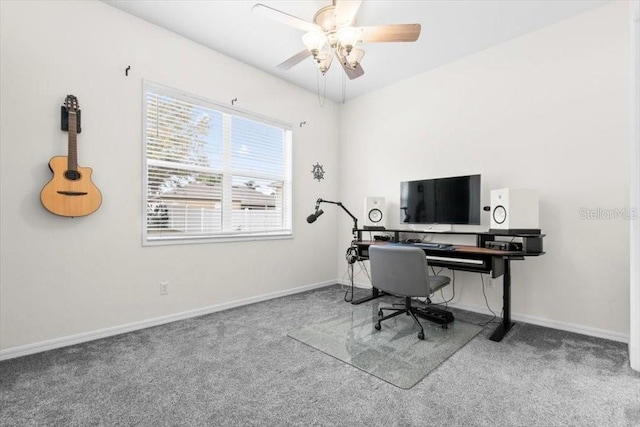 carpeted office with a ceiling fan and baseboards