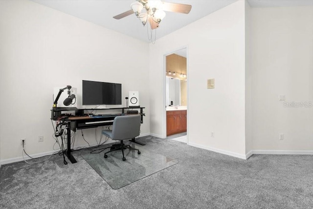 carpeted home office featuring baseboards and a ceiling fan