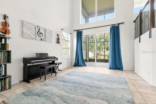 living area with a towering ceiling and tile patterned floors