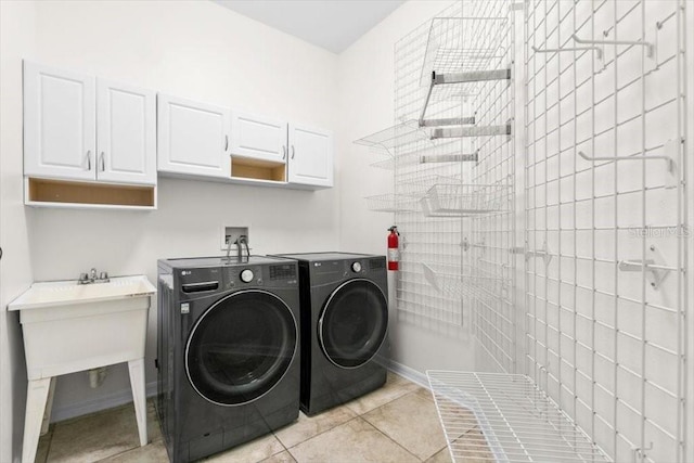 laundry room with cabinet space, washing machine and clothes dryer, and light tile patterned floors