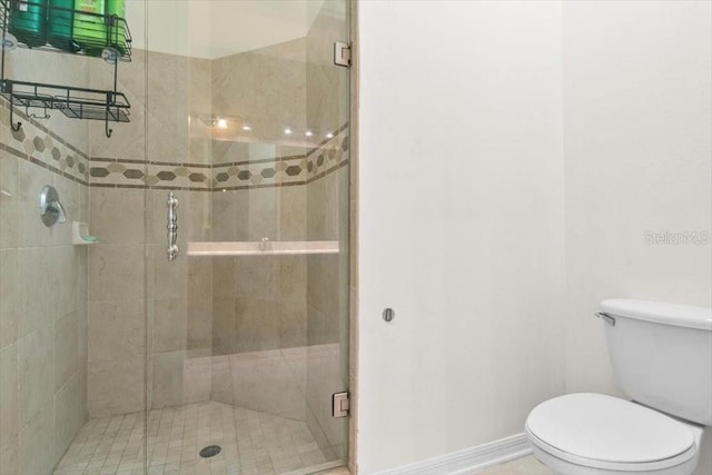 full bath featuring a stall shower, toilet, and baseboards