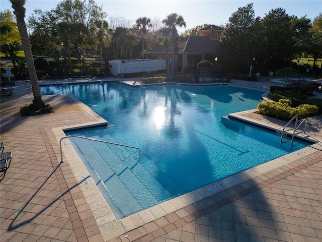 community pool with a patio area and a jacuzzi