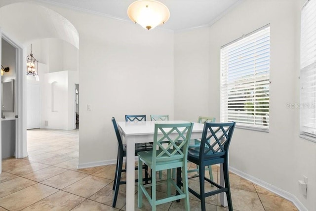 dining room with light tile patterned floors, baseboards, and ornamental molding