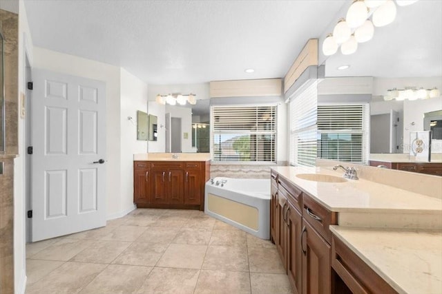 bathroom featuring two vanities, tile patterned flooring, a sink, and a bath