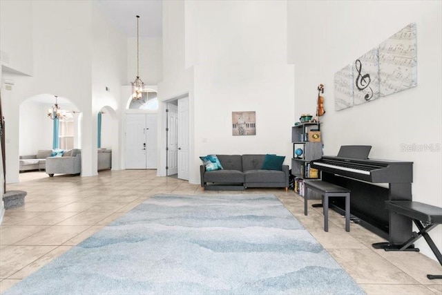 tiled living area featuring arched walkways and an inviting chandelier