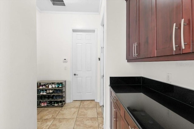 kitchen featuring ornamental molding, dark countertops, visible vents, and light tile patterned floors