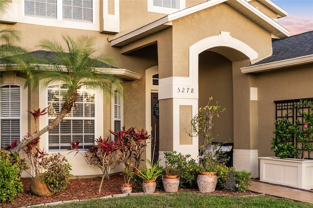 view of exterior entry featuring stucco siding