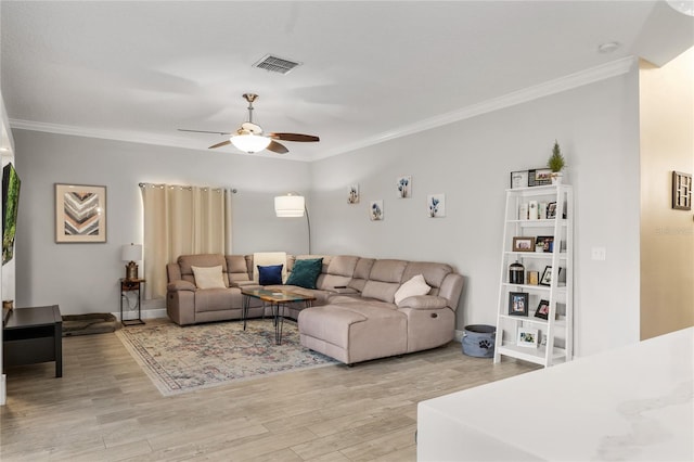 living room featuring visible vents, crown molding, and light wood finished floors