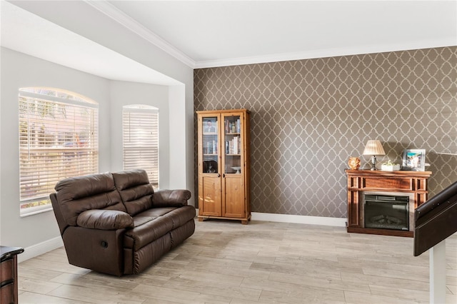 living room featuring light wood finished floors, wallpapered walls, crown molding, baseboards, and an accent wall